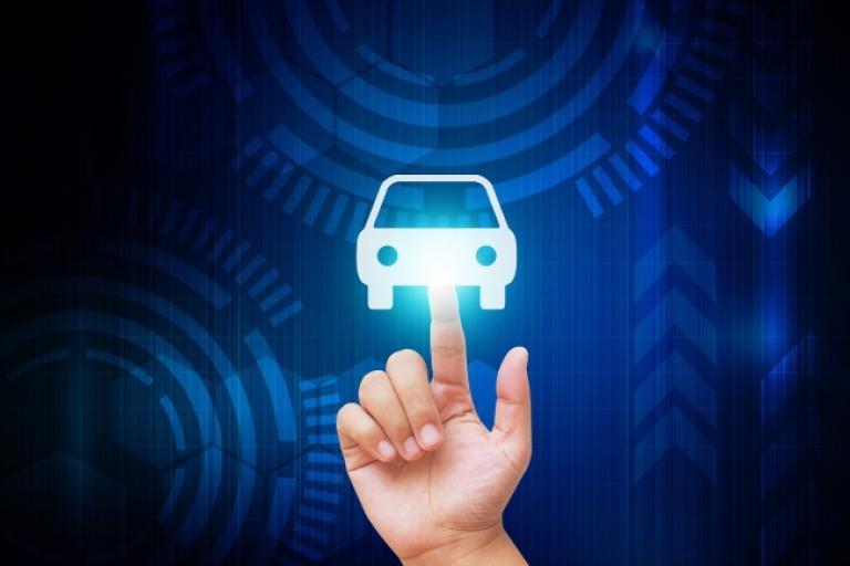 Mão tocando ícone de carro brilhante em uma interface digital azul futurista.