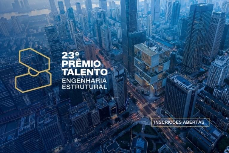 Vista aérea urbana com edifícios modernos e destaque para prêmio de engenharia estrutural com inscrições abertas.