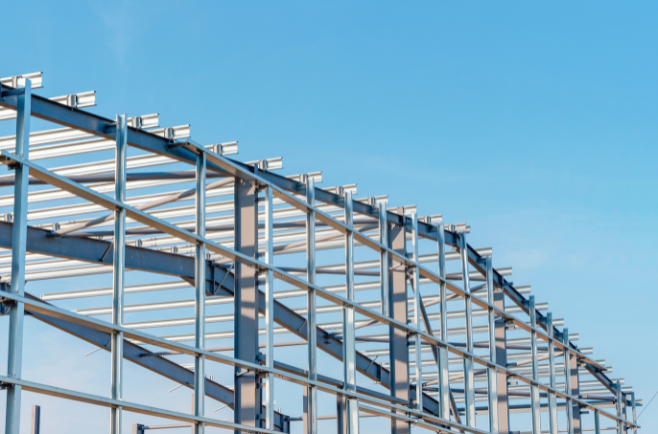 Estrutura metálica de galpão industrial em aço, com vigas e pilares metálicos sem fechamento, em fase de montagem.