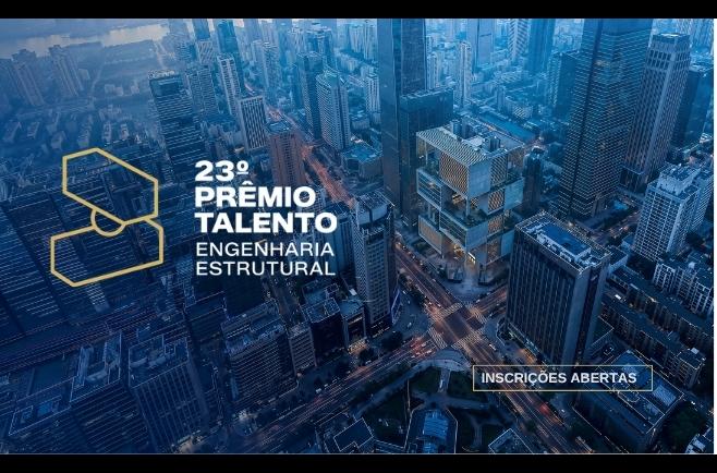 Vista aérea urbana com edifícios modernos e destaque para prêmio de engenharia estrutural com inscrições abertas.