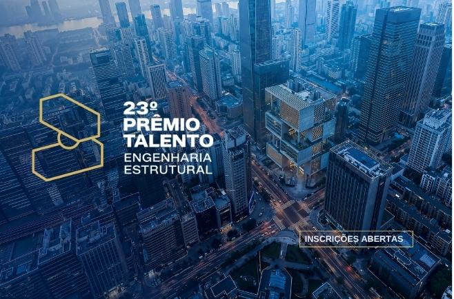 Vista aérea urbana com edifícios modernos e destaque para prêmio de engenharia estrutural com inscrições abertas.