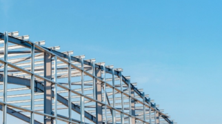 Estrutura metálica de galpão industrial em aço, com vigas e pilares metálicos sem fechamento, em fase de montagem.