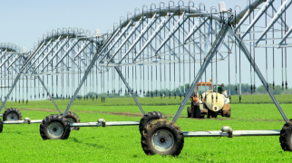 Sistema de irrigação por pivô central com estrutura metálica em área de cultivo agrícola, utilizado para distribuição de água na lavoura.