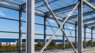 Estrutura metálica de aço com pilares, vigas e contraventamentos em galpão industrial em construção.